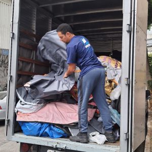 Pessoas descarregando as lonas do caminhão